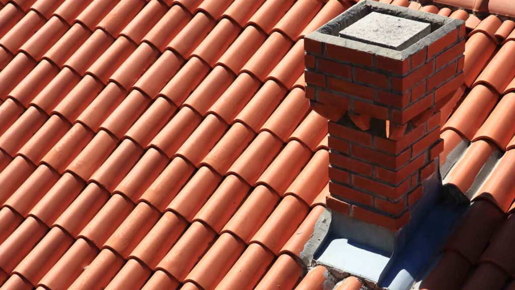 Close-up of red clay tile roof with a brick chimney