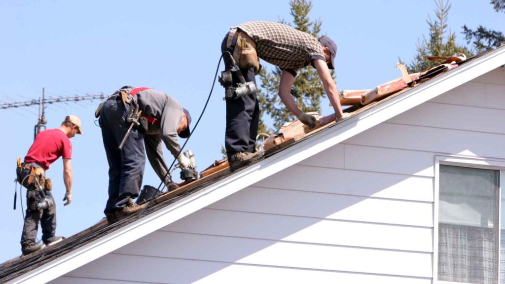 Roofing crew removes old shingles on a residential home.