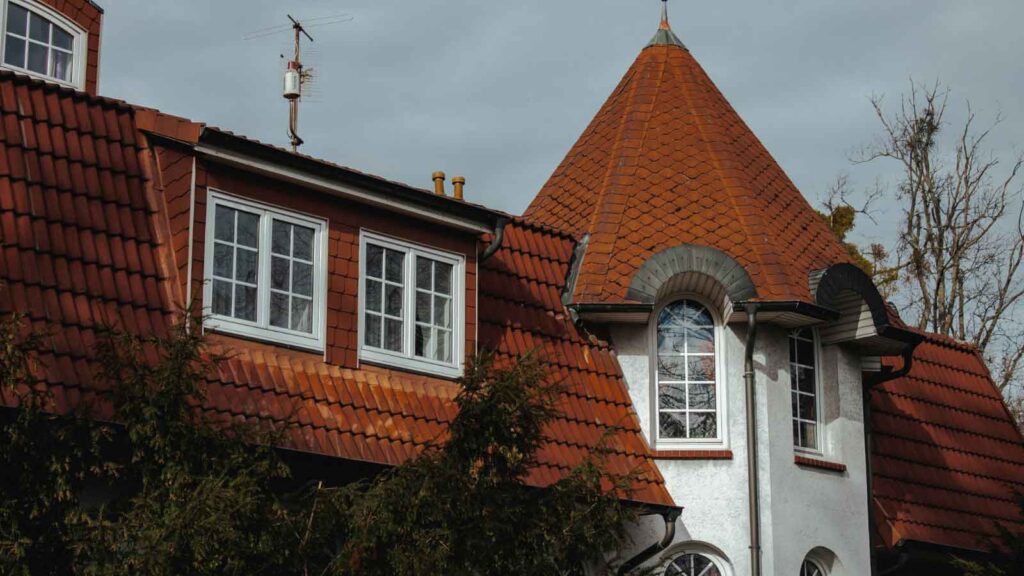 House with steep clay tile roofing and dormer windows.