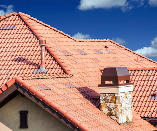 A house with a red tiled roof under a clear blue sky