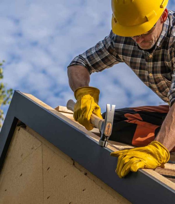 Roofer securing a roof edge with precision and safety gear