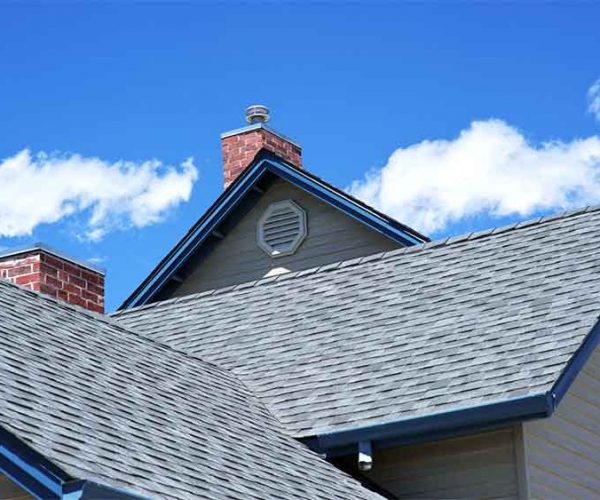 Rooftop-with-dormers-and-chimneys-against-a-blue-sky-with-clouds